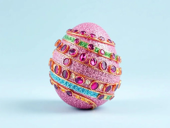 Pink glitter egg encrusted with pink ruby garnets, with spiral bands of Garnetts wrapped around in a helix with colors arranged as rainbow stripes